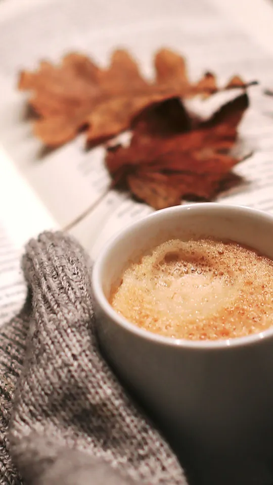 Tazzina di caffè con foglie rosse autunnali